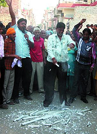 Former municipal councillor Vijay Kumar breaks tubelights to protest against the inflated power bills issued to consumers, at Paras Ram Nagar in Bathinda on Thursday