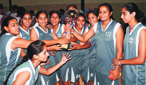 Winners of the basketball tournament with the trophy in Ludhiana on Friday.