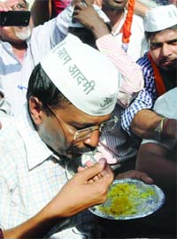 IAC activist Arvind Kejriwal eats with his supporters after being released from Bawana Jail