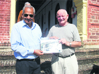 Swedish national Roland Johansson being presented with a rare picture of Mussoorie by a local historian during his visit to Mussoorie. 