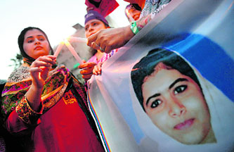 A Pakistani demonstrator lights a candle during a protest in Karachi against the assassination attempt on child activist Malala Yousafzai.