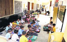 Students sit in the corridor due to dearth of adequate rooms and furniture
