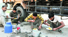 Truckers having a meal on the Narwal-Sidhra bypass road on the outskirts of Jammu city on Saturday