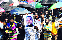 A miner holds the portrait of a colleague who died during clashes with police in Rustenburg