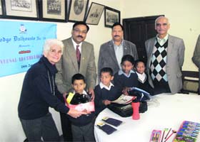 Members of the Freemasons community distribute uniforms and bags to students of Government Primary School in Mussoorie on Sunday