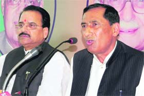 President of the state unit of the BJP Bishan Singh Chuphal addresses the media as senior party leader and MLA Ajay Bhatt looks on in Dehradun on Sunday