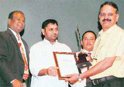 Postal employee recieves an award from the Member of Parliment Madan Lal Sharma during the postmasters' conference at Police Auditorium, Gulshan Ground, Jammu, on Sunday. 