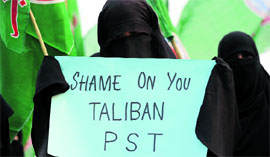 A veiled activist of an Islamic party carries a placard during a protest against the Talibans attempt to kill Malala Yousafzai, in Islamabad.