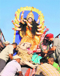 Devotees carry an idol of Goddess Durga on the eve of the Navaratras near the airport in Chandigarh on Monday.