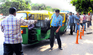 Members of the Auto-rickshaw Operators Union stop autos plying on the roads in Chandigarh on Monday.