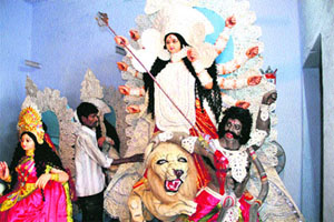 An artist gives the finishing touches to the idol of Durga on the eve of Navratras in Dehradun on Monday.