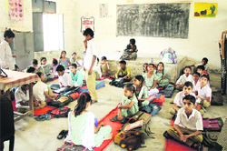 Government Elementary School, Kot Sadiq, sit on the floor as they attend classes.