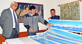 Governor NN Vohra looks at photographs of mountain ranges in Kashmir.
