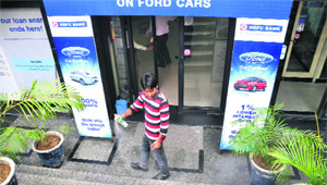 A bank worker sprays air freshener after the body of the security guard was removed from the spot in Ludhiana on Monday. 