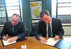 Scotlands First Minister Alex Salmond (L) and British PM David Cameron ink deal in Edinburgh on Monday. 