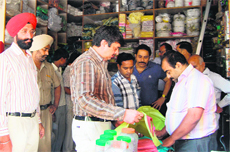 MC health officer Yogesh Arora and other officials scrutinise polythene carry bags being used by shopkeepers in Amritsar on Tuesday. 