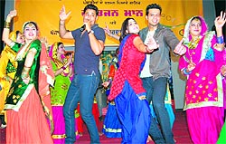 Singer-actor Harbhajan Mann, actor Gulzar Chahal, and actress Neetu Singh perform dance with girls from a gidha team to promote their upcoming film "Dil Tenu Karda Ae Pyar" at the Khalsa College for Women