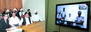 District and Sessions Judge SK Aggarwal (third from left) hearing a case through videoconferencing (right) in Bathinda on Wednesday.