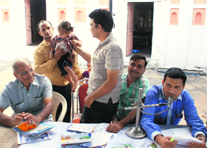 An official of the information centre reunites a lost child with her father at the Mansa Devi temple in Panchkula on Wednesday.