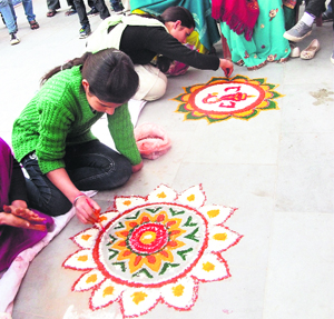 Participants make a rangoli pattern during the Durga Puja mela in Mussoorie on Wednesday.