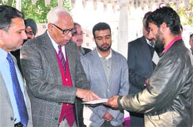 Governor NN Vohra hands over a cheque to a ponywalla at Raj Bhawan
