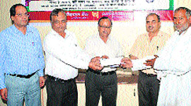 Chief Manager SK Goyal and other bank officials present a loan to a farmer at the PNBs loan fair in Rewari. 