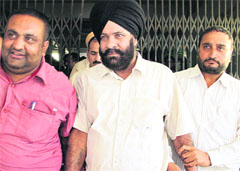Kanungo Jarnail Singh, who was caught taking bribe, in the custody of a Vigilance team in Jalandhar on Thursday. Photo: Sarabjit Singh