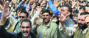 Members of the Jammu and Kashmir Urban Local Bodies Employees United Forum raise slogans against the state government in Srinagar on Thursday. 