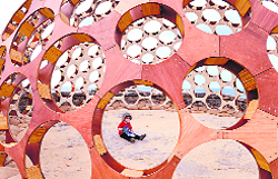 A child sits in the interior of a plywood, timber and perspex dome titled Mirador at the Sculpture by the Sea exhibition in Sydney on Thursday