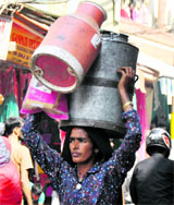 A Gujjar woman carries milk containers in Jammu.