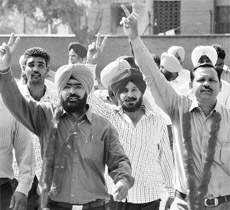 Avtar Singh Guram (left) celebrates after winning the Punjab Agricultural University Class IV Employees Union elections in Ludhiana on Friday. 