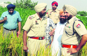 Police officials inspect the spot where Jagpal Kaur was shot dead at Noorpura village near Raikot. 
