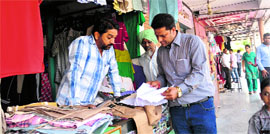 Teams of the UT Estate Office verify the credentials of the shopkeepers at the booths in the Sector 41 Krishna Market on Saturday.