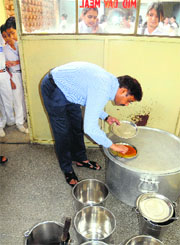 While children peep in, Joint Secretary, Estates, SK Setia checks mid-day meal at GMSSS, Mani Majra, in Chandigarh on Saturday.