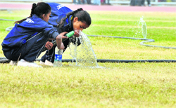 Players drink water from a sprinkler pipe at Guru Nanak Stadium in Ludhiana on Saturday. 