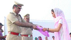 Arun Singh, SSP, honours a widow on the occasion of Police Martyrs Day in the Sonepat Police Lines on Sunday.