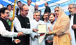 Union Minister for Health and Family Welfare Ghulam Nabi Azad along with Union Minister for Parliamentary Affairs Pawan Kumar Bansal felicitate a martyrs family at Bishnah in Jammu on Sunday