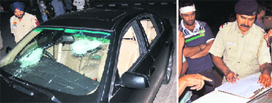 The damaged BMW car; and (right) a policeman records the statement of the victim (with a bandage on his forehead) at Sector 10, Chandigarh, on Monday. Tribune photos: Pradeep Tewari 