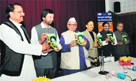 Governor Aziz Qureshi releases a book by Prakash Pant, former Cabinet minister (second from left), 