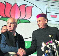 Shanta Kumar shakes hands with PK Dhumal after the release of the election manifesto of the BJP in Shimla on Monday.