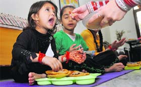 A girl takes prasad during ashtami puja in Ludhiana on Monday.