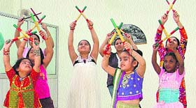 Students learn dandiya at a dance class.