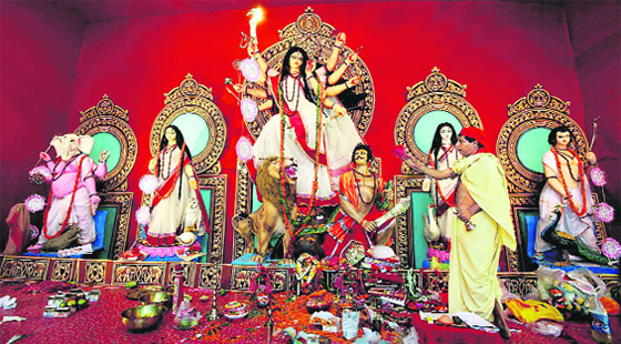 A priest offers prayers at a puja pandal on the occasion of Mahashtami in Kolkata on Monday. 