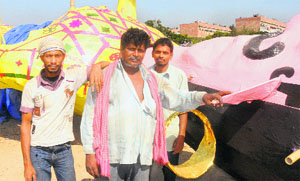 Jamil Ahmed (centre), a craftsman, strikes pose with other artisans in front of an effigy at the Sector 46 Dasehra Ground in Chandigarh on Tuesday.