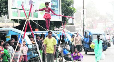 A young girl performs a balancing act on a rope at a street in Dehradun on Tuesday.