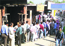 A long queue of cooking gas consumers wait for their turn for verification of their gas connections at Nurpur.