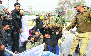 The police detains Health Department employees after they tried to block a road near the Press Club in Srinagar on Tuesday. They were protesting against non-payment of their salaries. 