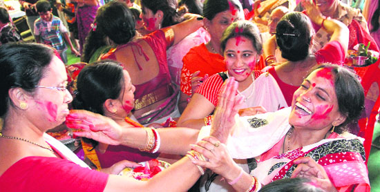 Women apply vermilion on each others faces to celebrate Dasehra in Dehradun on Wednesday. 