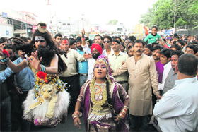 Artistes dressed as Lord Shiv and Goddess Parvati move towards the venue of the Dasehra celebrations in Dehradun on Wednesday. 