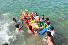 Devotees immerse an idol of Goddess Durga in the Tawi river in Jammu on Wednesday. 